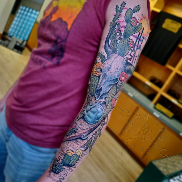 Cactus skull desert with cactus in flower full color sleeve tattoo. Book a custom tattoo with John at Sacred Mandala Studio - Durham, NC.